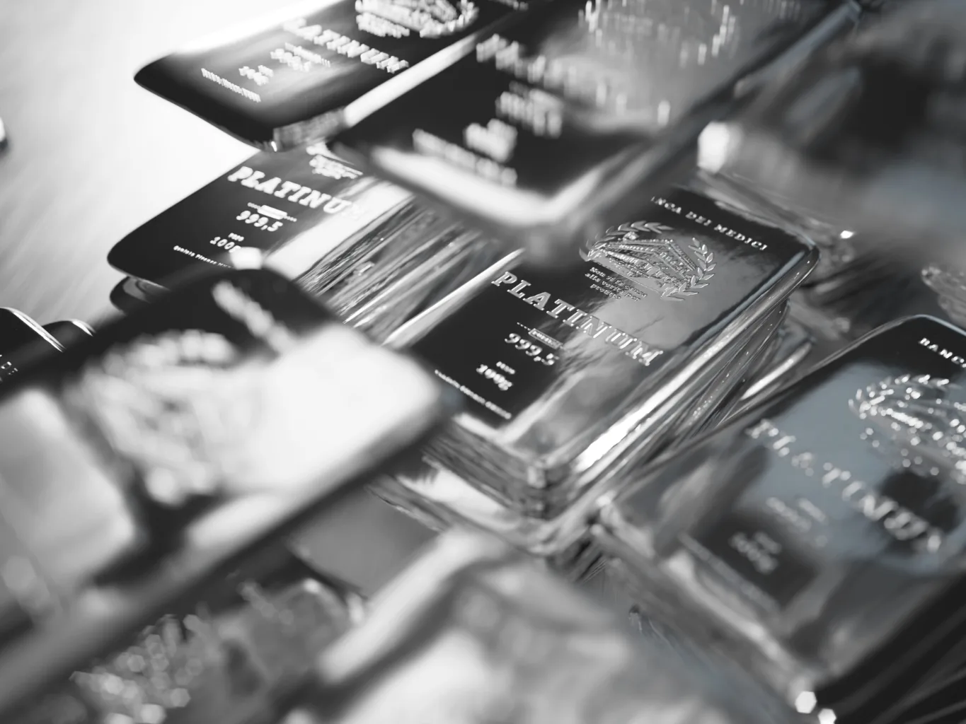 At the verification stage of a platinum and silver evaluation, a worker uses a platinum testing file to make a small test mark on a platinum piece beside silver items on a dark tray