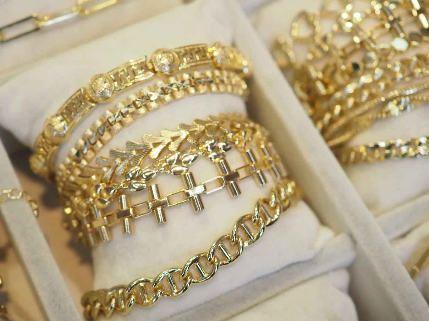 At the condition-review stage of a gold bracelet evaluation, a worker places a bracelet around a jewelry mandrel and checks the links and clasp with a fine inspection pick